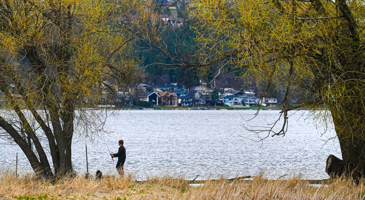 A fisherman walks along the bank at Liberty Lake Regional Park on Wednesday. The county will be making $2.4 million worth of improvements to the park this summer.  (Kathy Plonka/The Spokesman-Review)