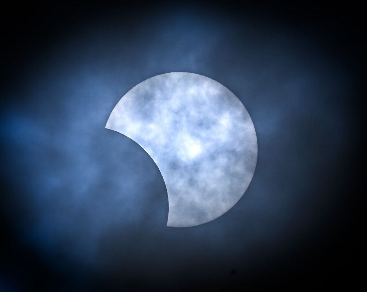 A partial solar eclipse is seen through the clouds over downtown Spokane on Monday.  (DAN PELLE/THE SPOKESMAN-REVIEW)