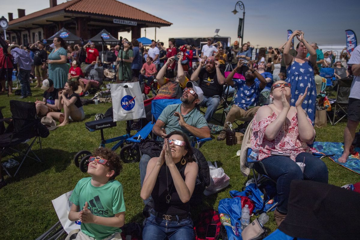 People react as the solar eclipse reaches totality at a festival in Russellville, Ark., on Monday.   (Jonathan Newton/For The Washington Post)